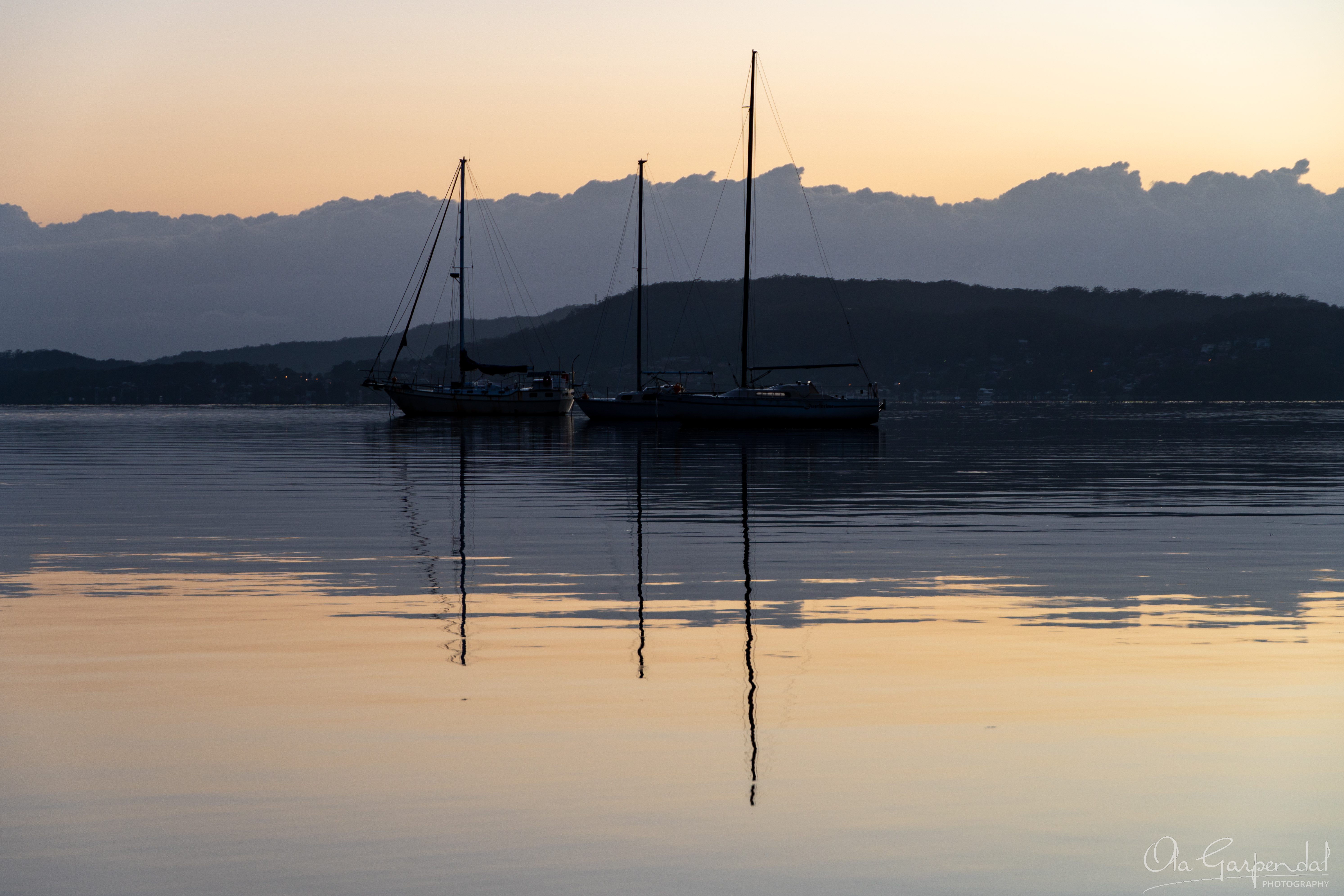 Tascott Morning, sailing boats in silhouette with reflections in the still water, photographed by Ola Garpendal Photography