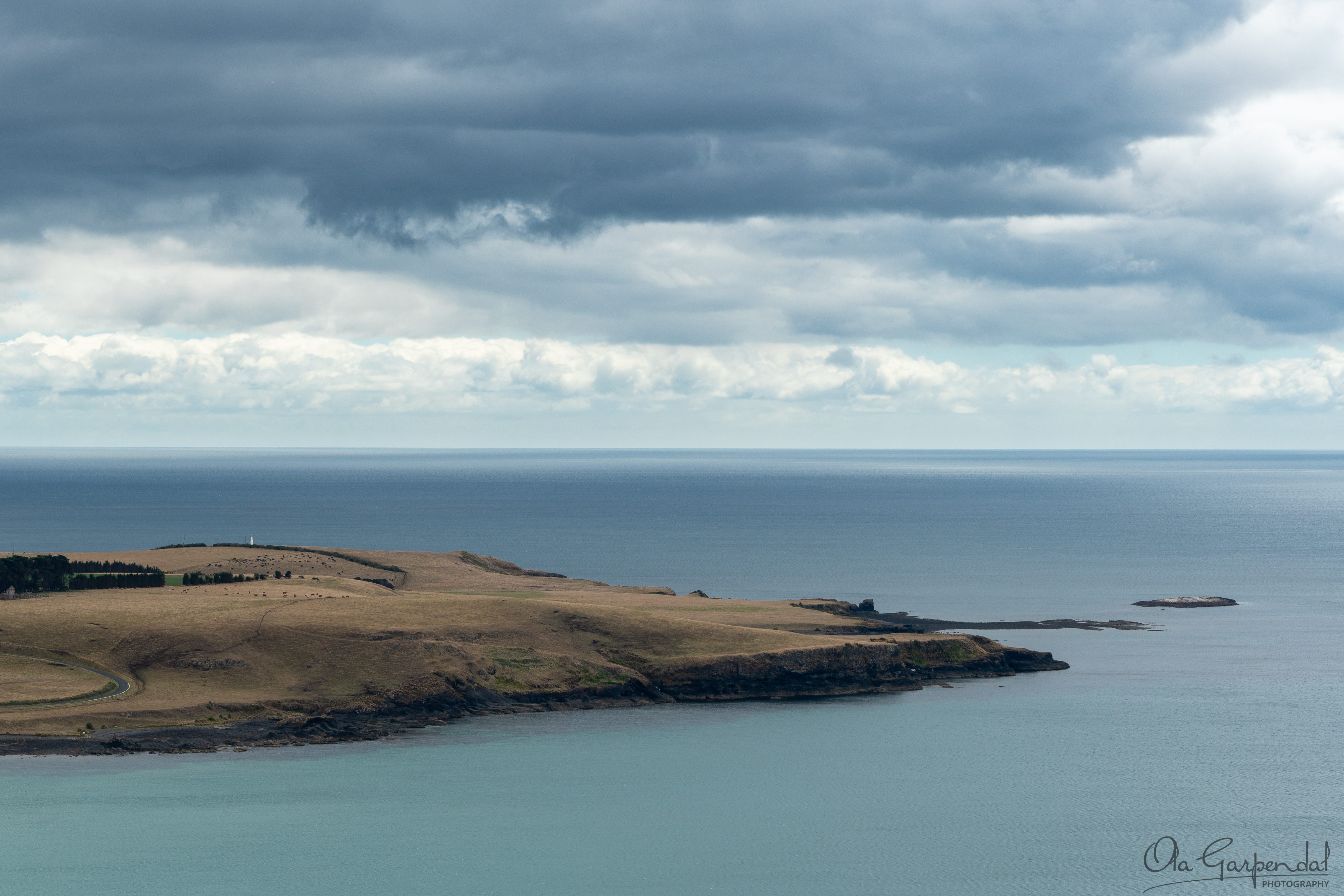 Walker Island showing rolling coastal headlands near Stanley in northern Tasmania, calm Bass Strait waters, dramatic layered clouds and soft blue and golden tones in March, photographed by Ola Garpendal Photography