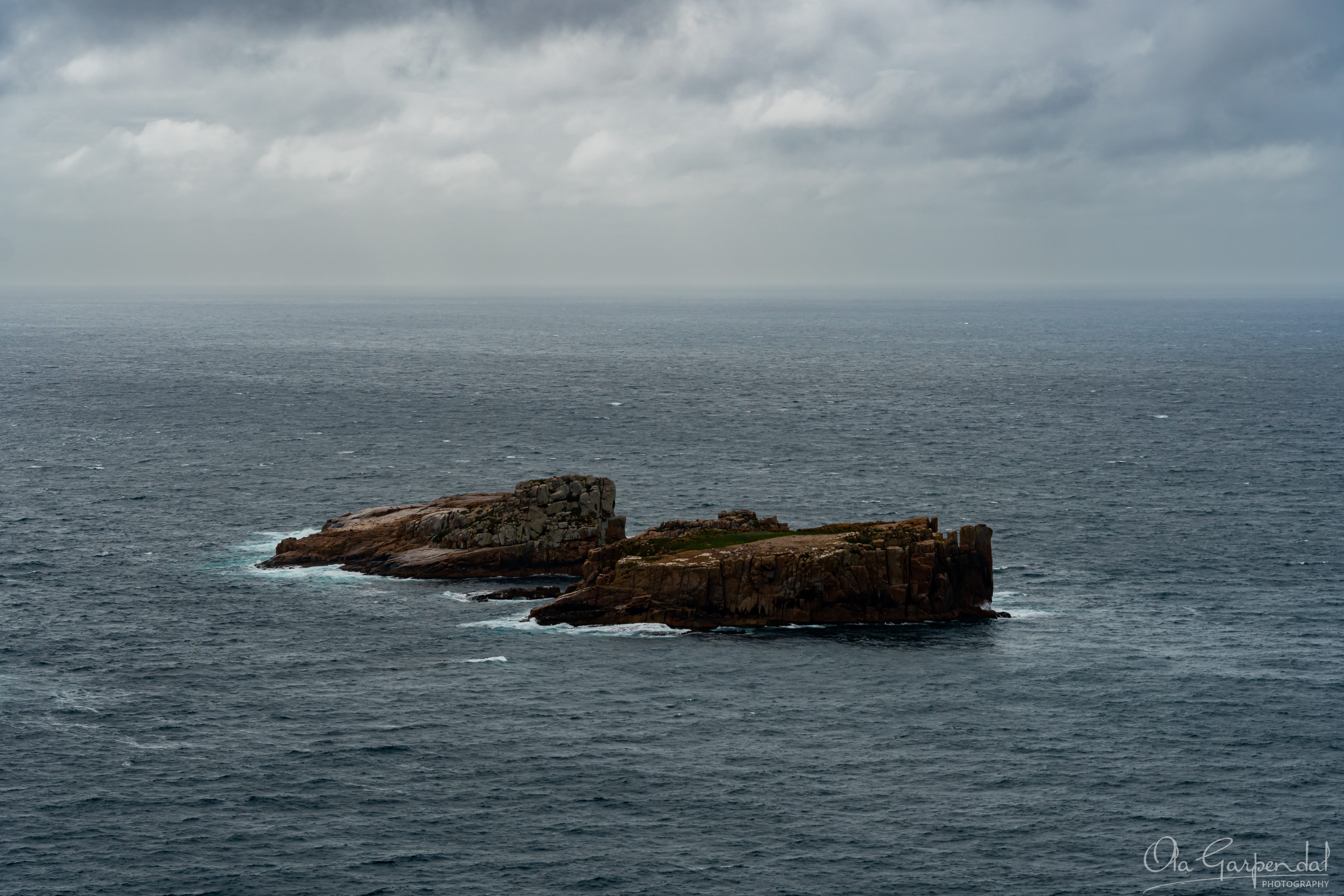 The Nuggets, two rocks, a vast ocean with a storm approaching, photographed by Ola Garpendal Photography