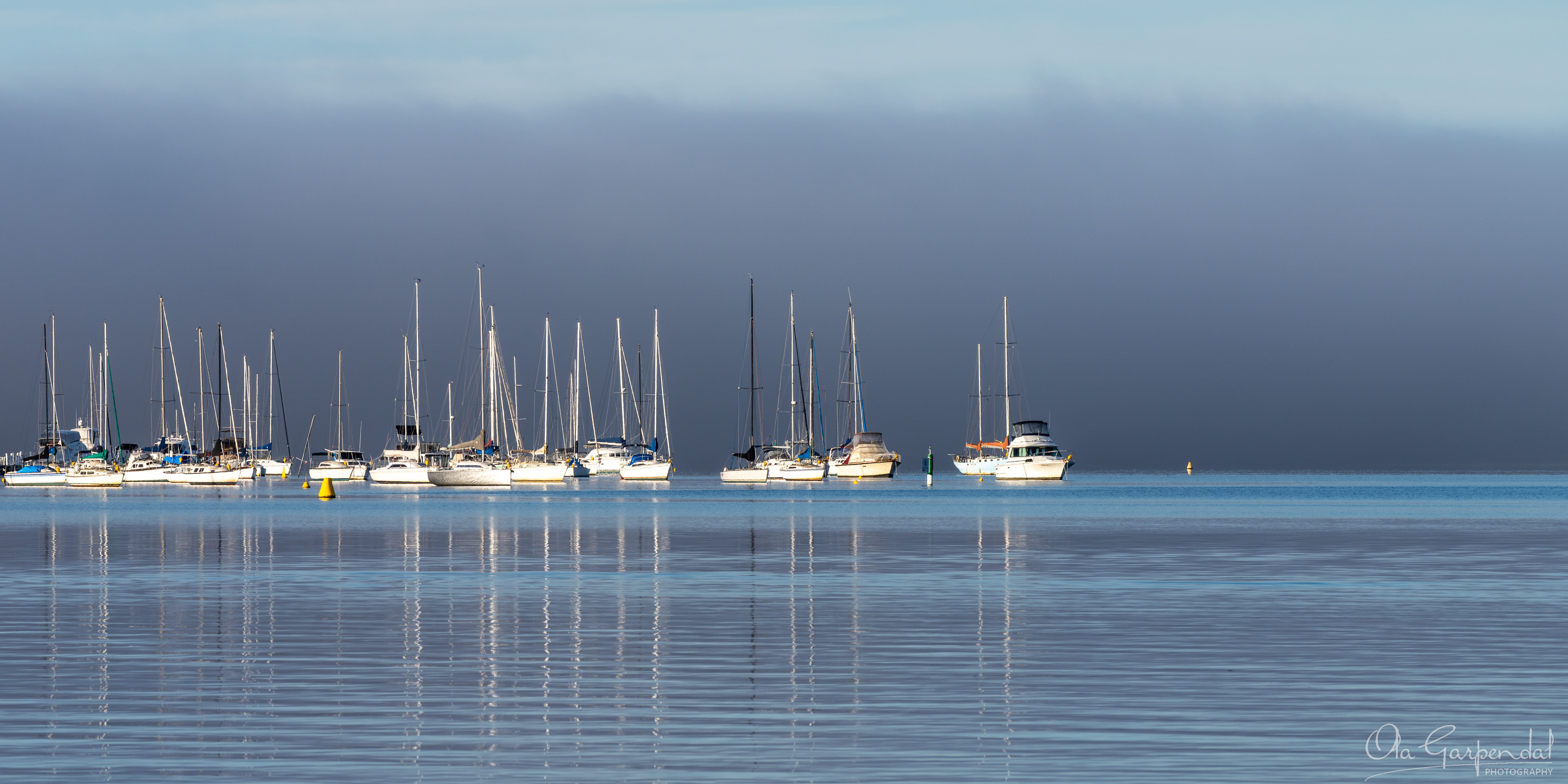 Floating in Fog, fine art print of moored boats and mast reflections on Brisbane Water in morning fog, viewed from Gosford Wharf toward Saratoga, NSW, photographed by Ola Garpendal Photography.