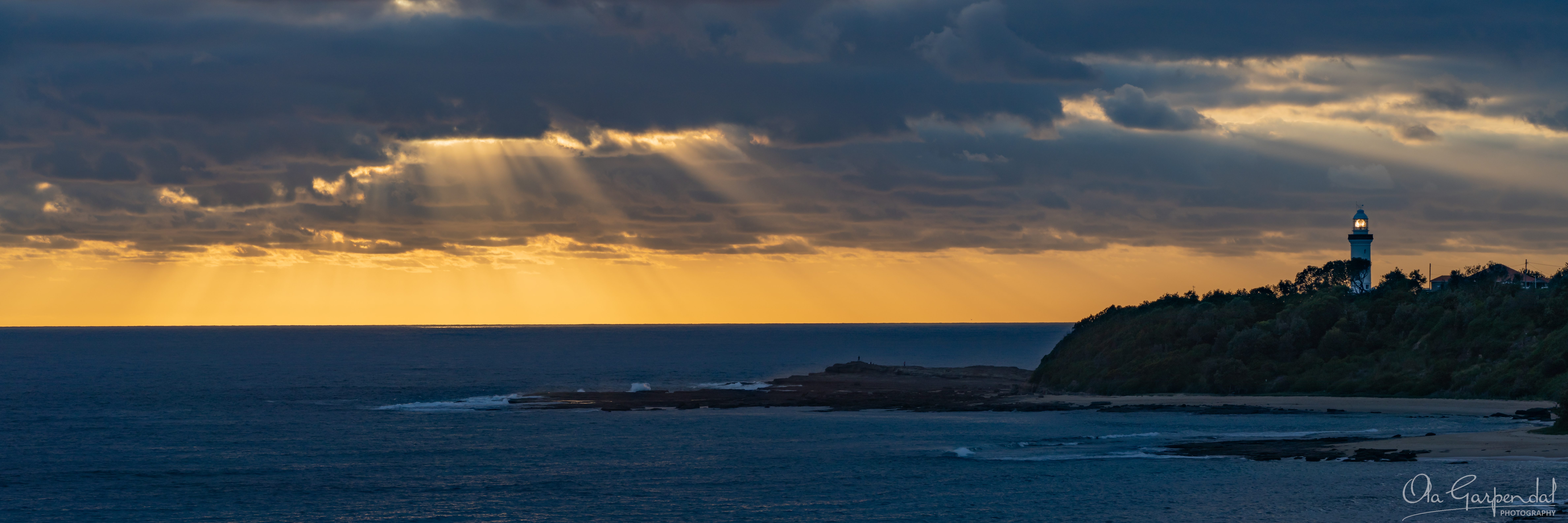Morning Breakthrough, fine art print of sun rays breaking through clouds over Norah Head Lighthouse, Central Coast NSW, photographed by Ola Garpendal Photography.
