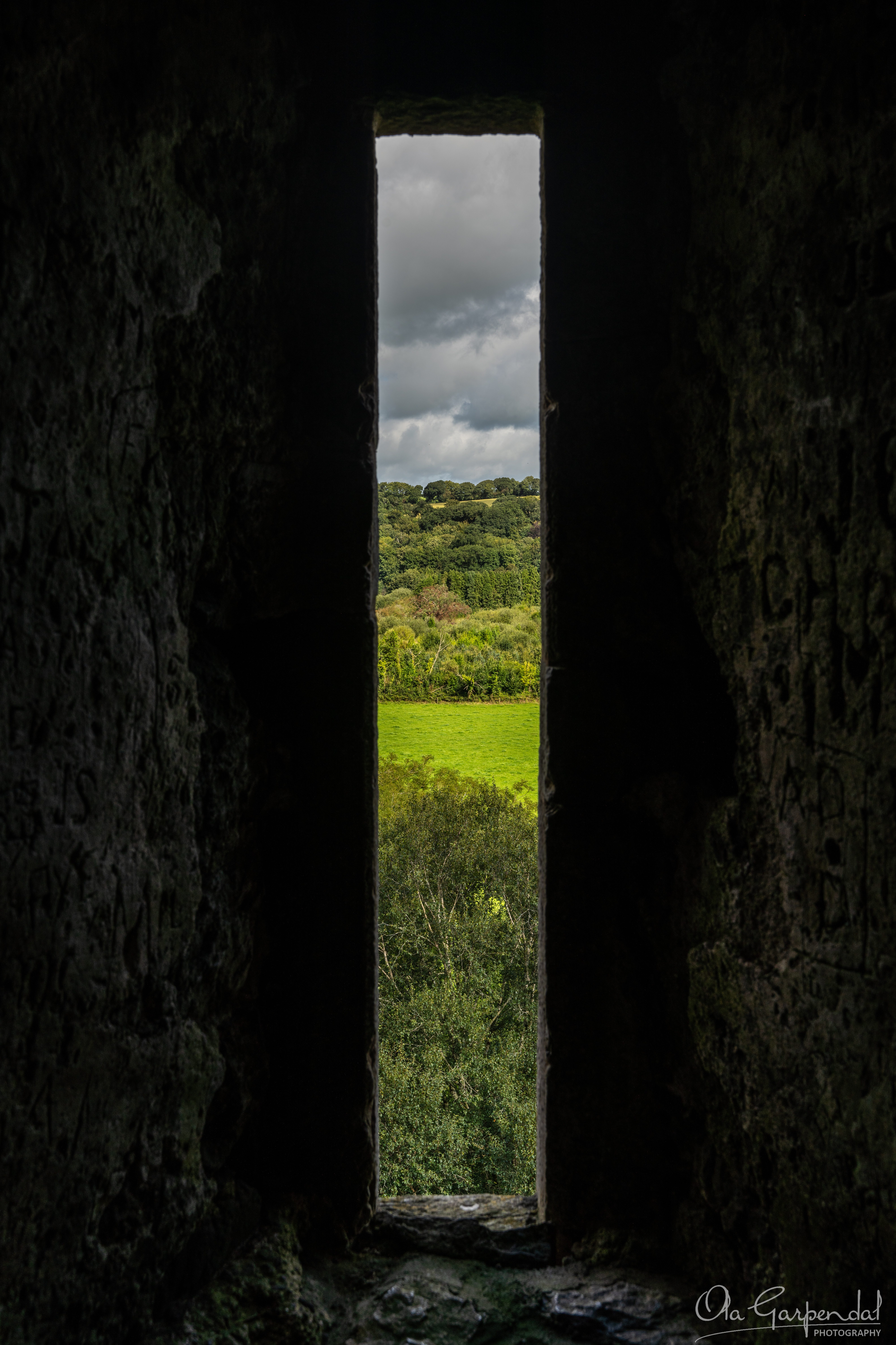 Blarney Castle Window, the thick castle walls frame the view of the outside landscape, photographed by Ola Garpendal Photography
