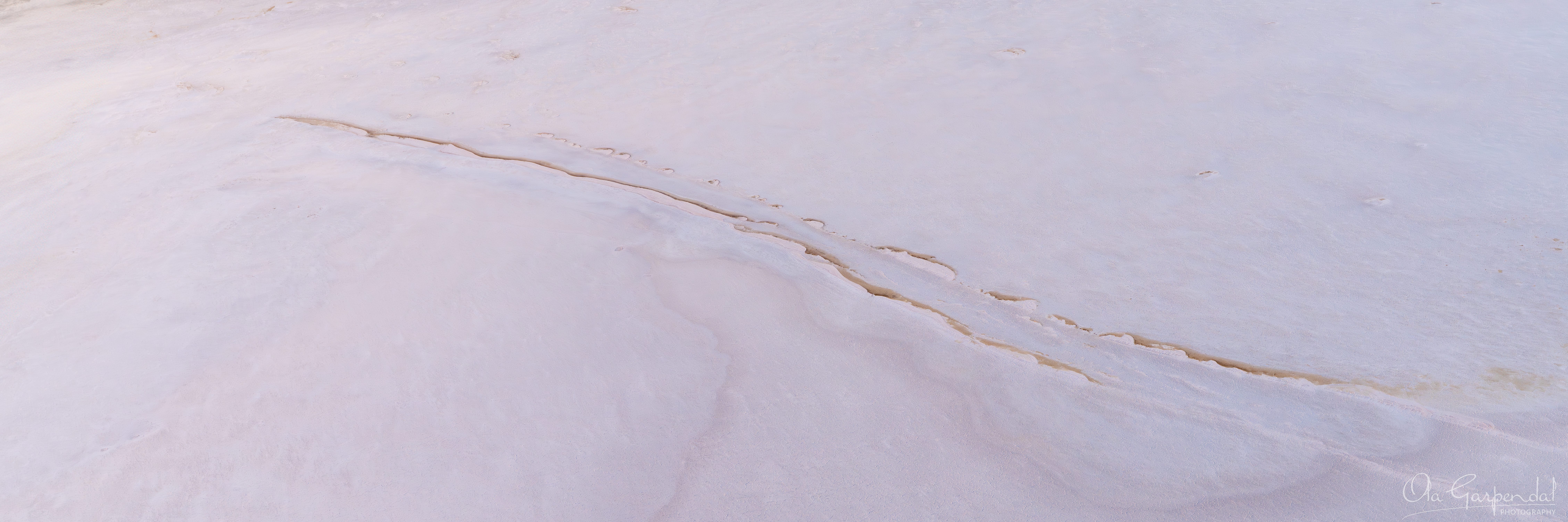 Sand Ridges, a pale, almost monochromatic expanse of white and blush-pink salt and sand, photographed by Ola Garpendal Photography